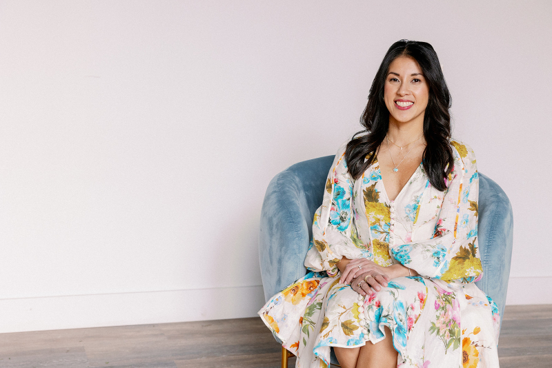 Desirée Adams sits in blue velvet chair, ready to discuss all things outdated wedding trends that should retire in 2026.