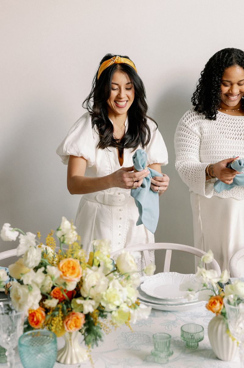 Desirée Adams stands with team member as they set a tablescape, talking about all the things she would do if she were starting a wedding planning business in 2026.