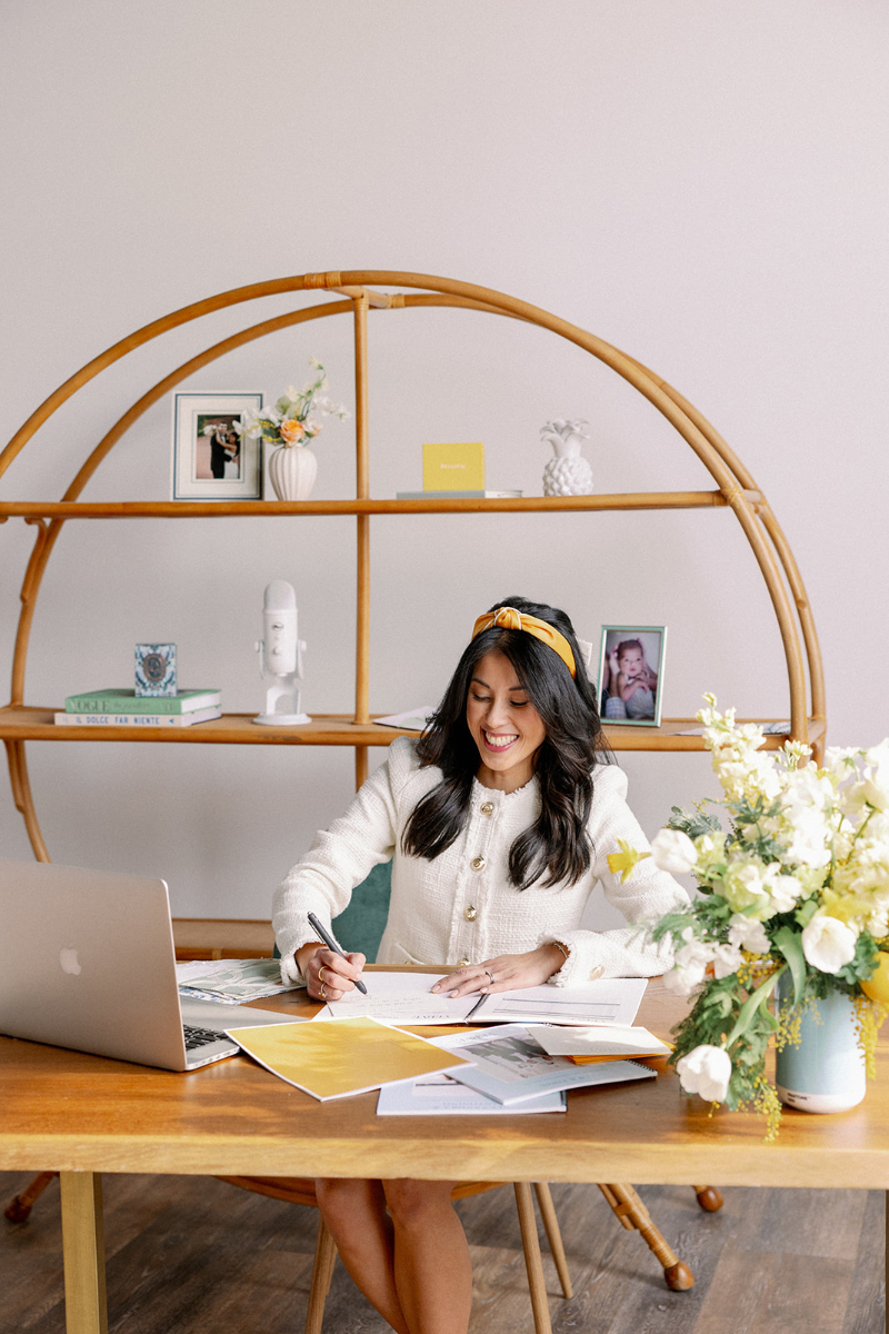 Desirée Adams sits at desk with a pen in hand as she writes out how she uses short-form content in her wedding planner marketing plan.