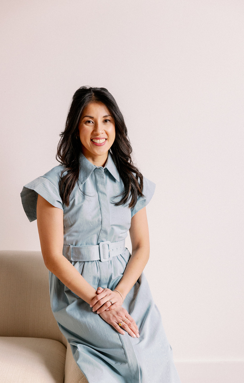 Desirée Adams sits for her wedding planner branding photoshoot in a blue dress.